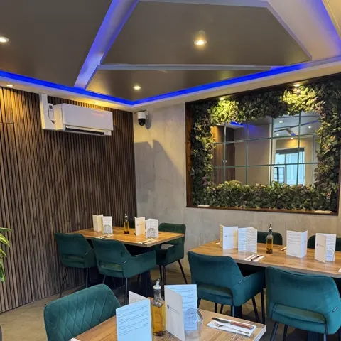 La salle de Due Fratelli, banquettes vertes et mur végétal